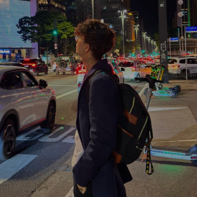 Luccas Soli de perfil, à noite, na Avenida Paulista